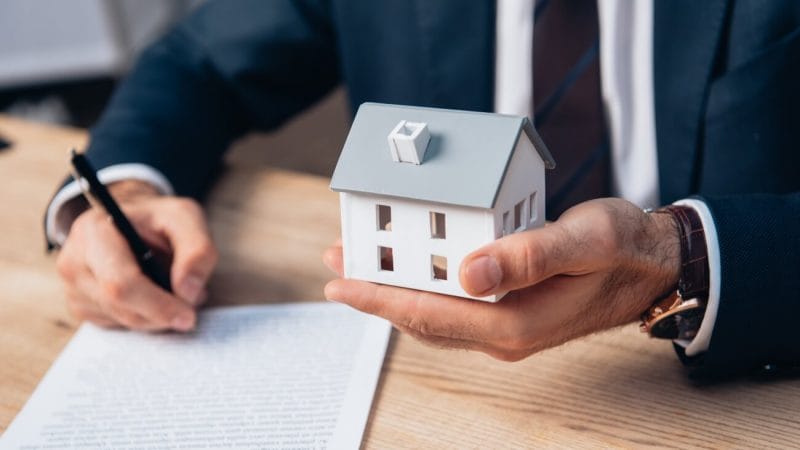 Man holding a model house in his hand